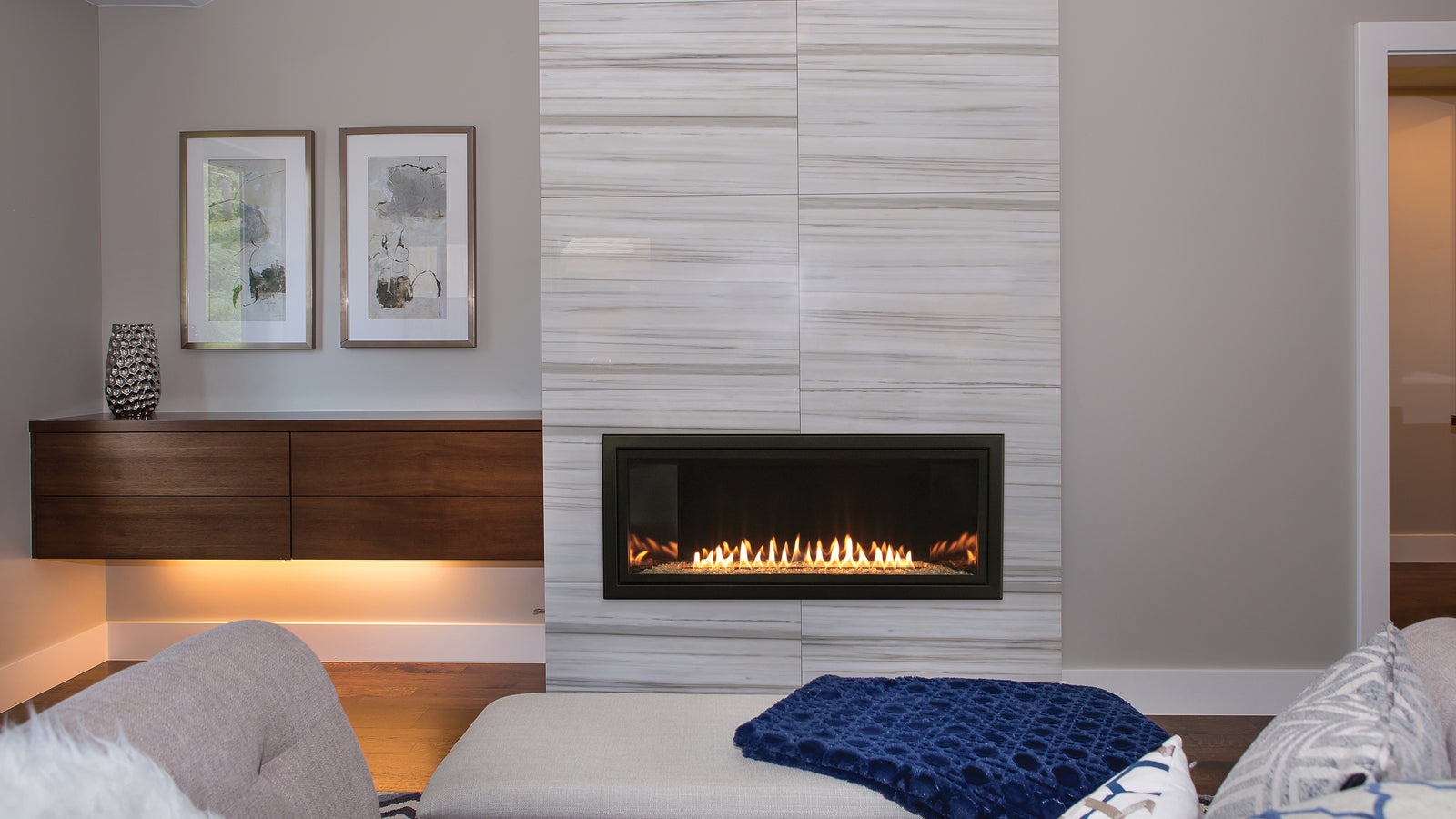 Empire Boulevard 36 inch linear gas fireplace in a tall tiled wall beside a bench