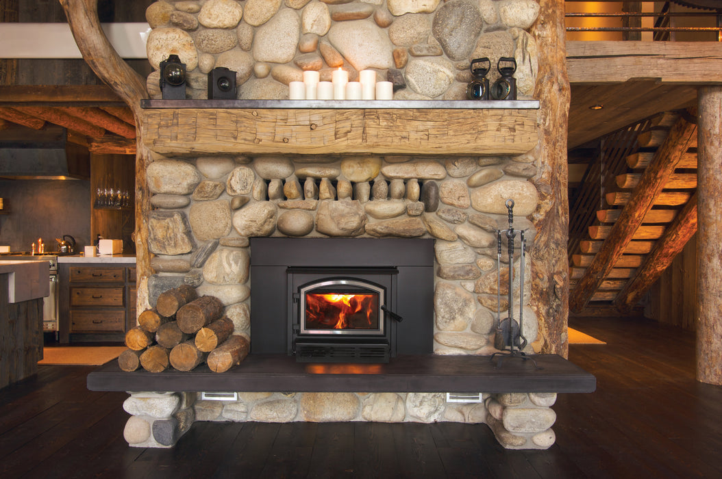 Empire Archway 2300 wood burning insert with nickel door trim in a rustic stone fireplace