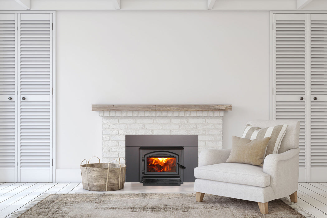 Empire Archway 2300 wood burning insert in a white painted brick fireplace with a reclaimed wood mantel