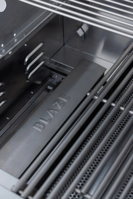 Blaze BCM grill flame tamer stamped with the Blaze name under the cooking grates, close-up