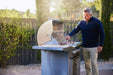 Man grilling on a Blaze LTE PRO 32" freestanding gas grill with the hood open
