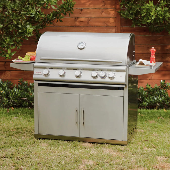 Blaze LTE+ 40" freestanding gas grill on a lawn in front of a wood fence, hood closed