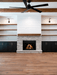 Empire Rainier 34 insert with birch logs and black glass in a stacked stone surround with shiplap and ceiling fan