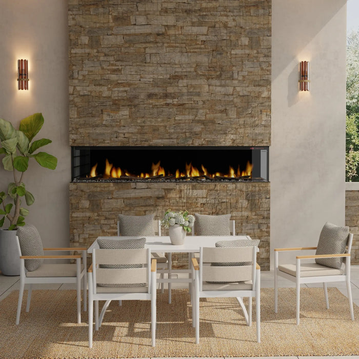 Dimplex Ignite Bold 100" Linear Electric Fireplace - installed in a stacked-stone wall on a covered patio above a dining table