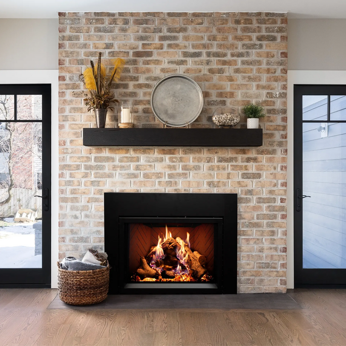 Empire 34" Rainier Premier insert in a brick fireplace with black mantel, wide view