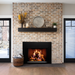 Empire 34" Rainier Premier insert in a brick fireplace with black mantel, wide view