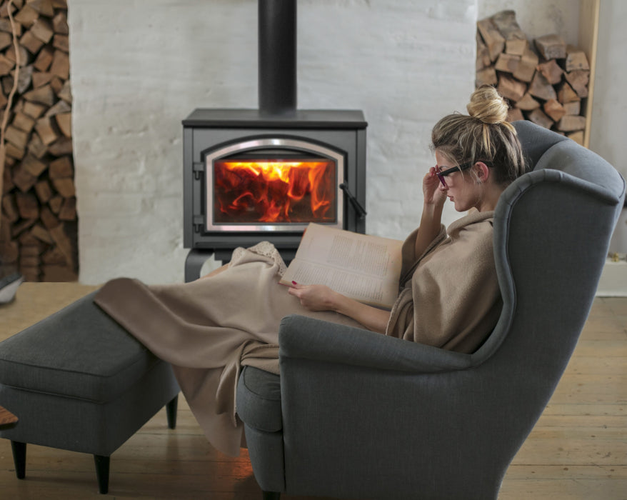 Empire Stove 26" Gateway 2300 Freestanding Wood Burning Stove, stove in a living room beside a reading chair