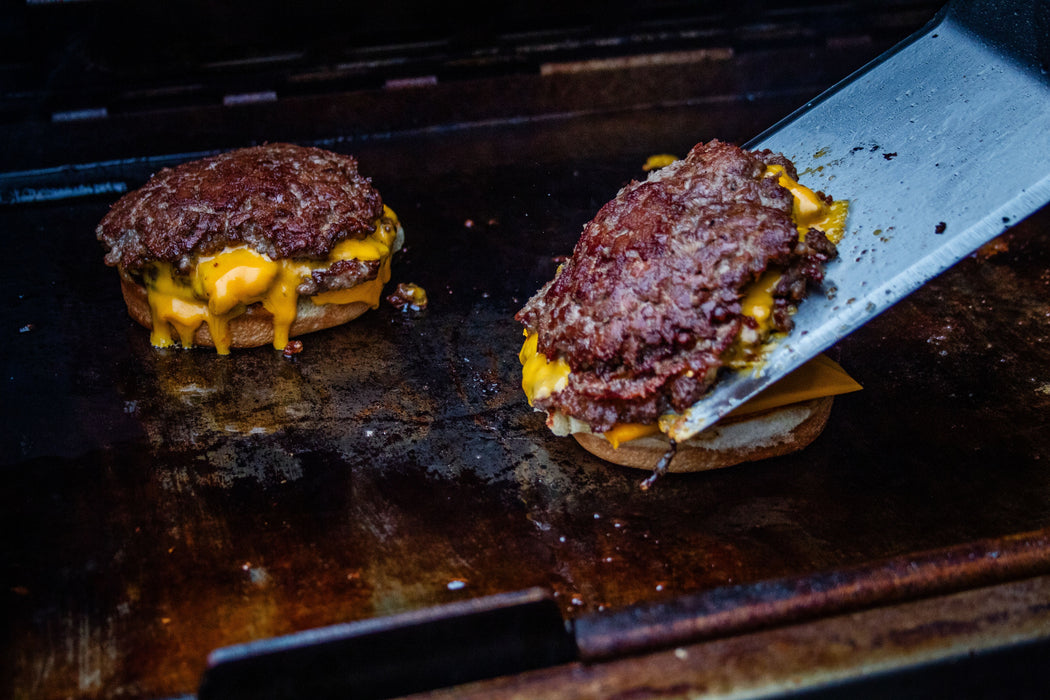 56041 2-sided Porcelain-Enameled Cast-Iron Griddle – in use, with burgers