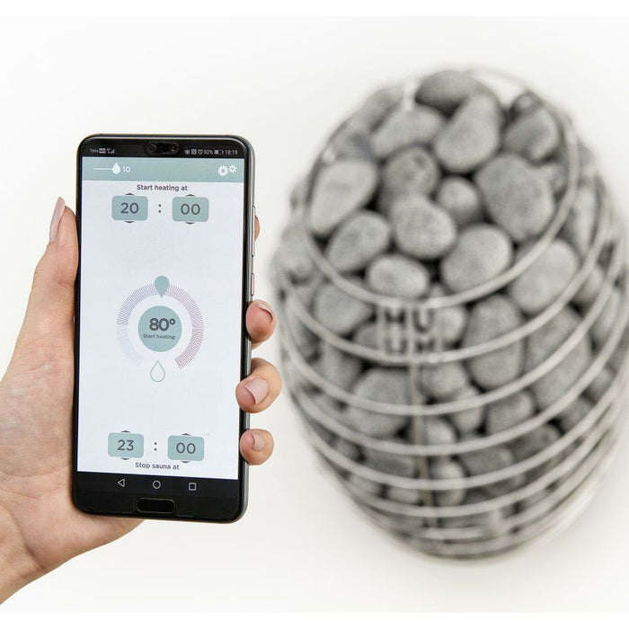 HUUM mobile app on a smartphone beside a HIVE sauna heater