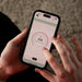 HUUM mobile app on a smartphone showing the sauna temperature dial