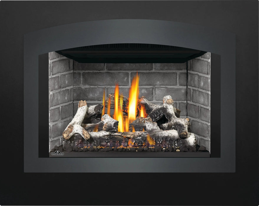 Napoleon Oakville X4 gas fireplace insert, small arched charcoal face with Westminster panels and birch logs