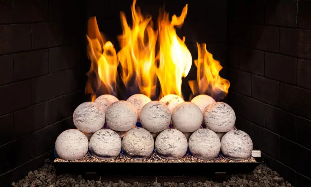 white marbled spheres stacked in a brick fireplace with flames behind them