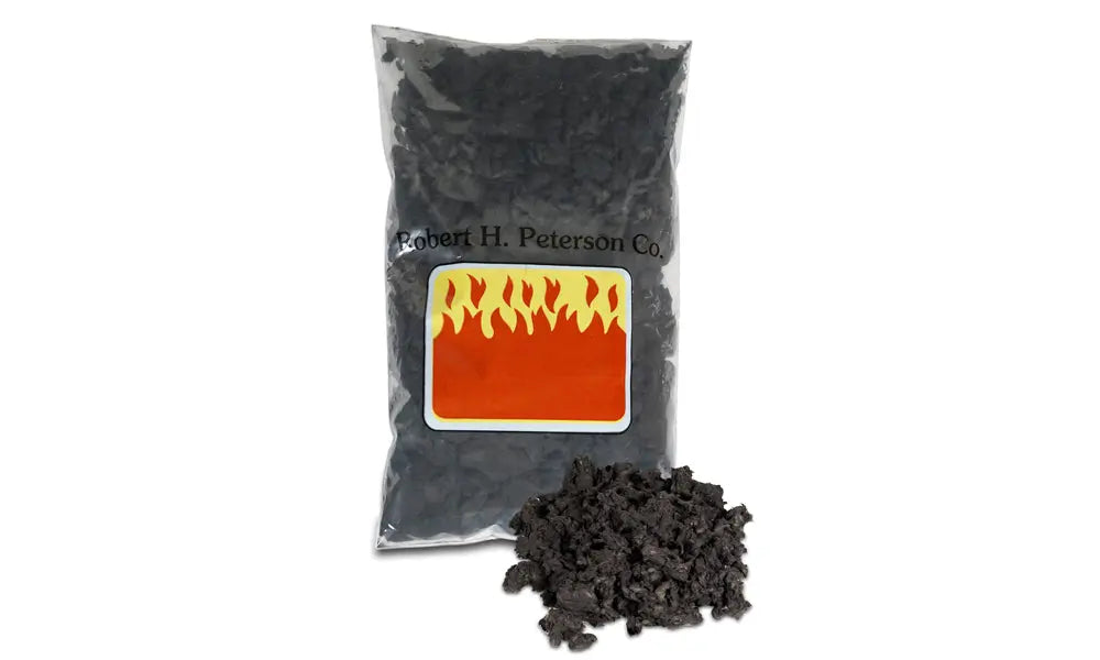 bag of black embers with a loose pile beside it