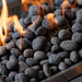 The Outdoor GreatRoom Tumbled lava rock in a burning gas fire pit