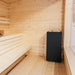 HUUM CORE Black electric sauna heater installed in the corner of a wood-lined sauna room
