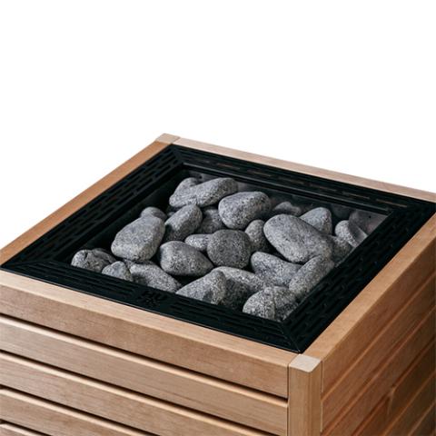 Close-up of the HUUM CORE sauna heater with thermo-aspen panels and black top grate filled with stones