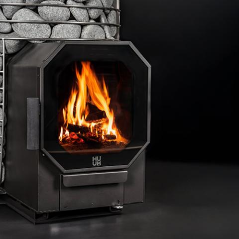 HUUM HIVE Flow sauna stove glass door with a fire burning
