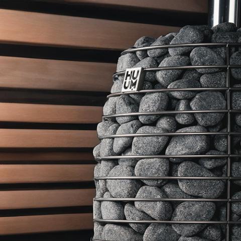 Close-up of sauna stones stacked in the HUUM HIVE Flow stone cage